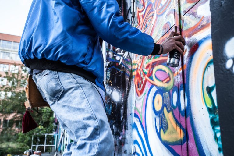 Graffiti : graffeur en train de tagguer un graff