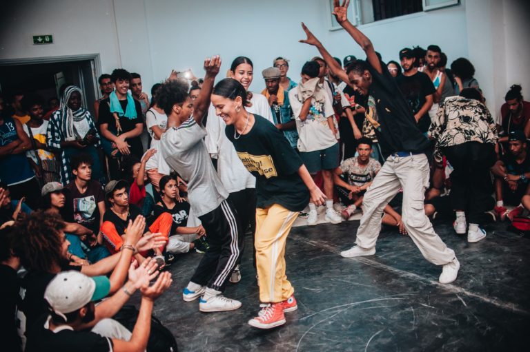 Battle de danse hip hop freestyle entre plusieurs danseurs, avec certains qui dansent au milieu du cercle autour du public